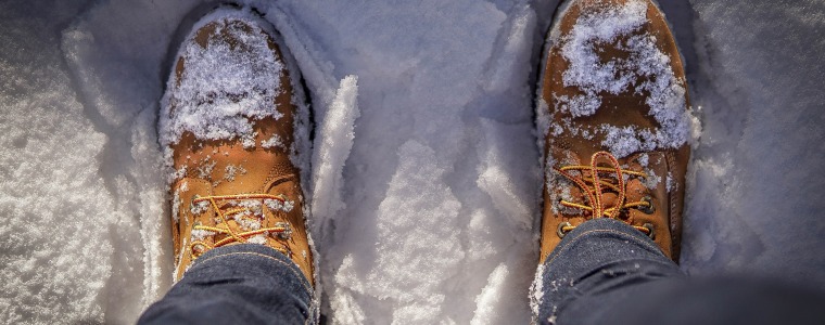Photograph of hiking boots while standing in snow.